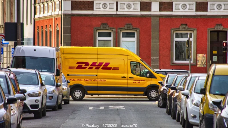 Ein Lieferwagen der deutschen Post bzw DHL in einer Strassenkreuzung